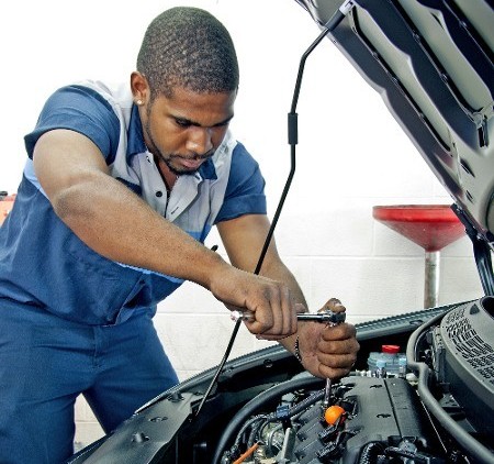 Mechanic Leaning Over Engine in San Antonio, TX